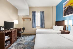 a hotel room with two beds and a flat screen tv at Days Inn by Wyndham Philadelphia Convention Center in Philadelphia
