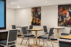 a conference room with tables and chairs and a monitor at Days Inn by Wyndham Philadelphia Convention Center in Philadelphia