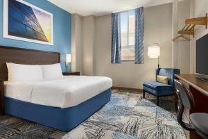 a hotel room with a bed, desk, and television at Days Inn by Wyndham Philadelphia Convention Center in Philadelphia