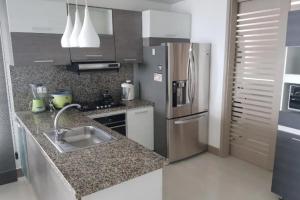 La cuisine est équipée d'un évier et d'un réfrigérateur en acier inoxydable. dans l'établissement Apartamento con Vista al Mar en Bocagrande Cartagena, à Carthagène des Indes