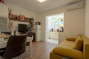 a living room with a couch and a kitchen at Apartman Citromelo in Split