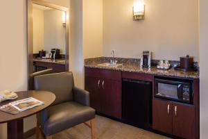 a hotel room with a kitchen with a sink and a table at Sonesta Chicago O'Hare Airport Rosemont in Rosemont +22 photos