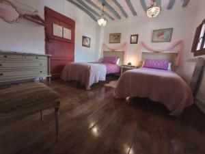 a room with two beds and a dresser in it at Riojania Heredad in Santa Eulalia Bajera