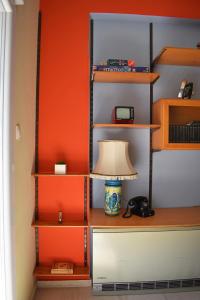 a lamp sitting on a table next to a shelf at Olive - HappyHostGr - Downtown Apartment in Volos