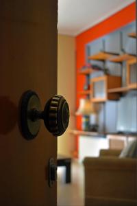 une poignée de porte menant à une chambre avec un canapé dans l'établissement Olive - HappyHostGr - Downtown Apartment, à Vólos