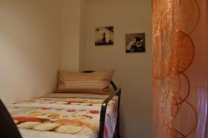 Dormitorio pequeño con cama y cuadros en la pared en Don Ciccio's House, en Fiumefreddo di Sicilia