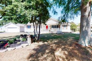 a white house with a red door and trees at Country Estates --- 15 Wagon Wheel in Ocean View