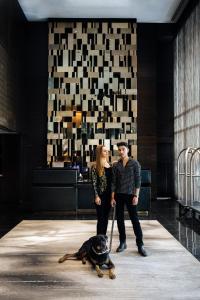 Un uomo, una donna e un cane al guinzaglio di Paradox Hotel Vancouver a Vancouver