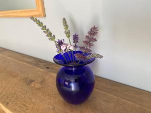 eine blaue Vase mit Blumen auf einem Tisch in der Unterkunft The Annexe in Filey
