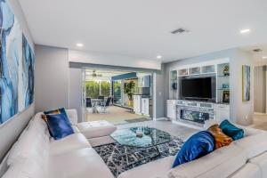 a living room with a white couch and a tv at Smiles and Sunshine in Cape Coral