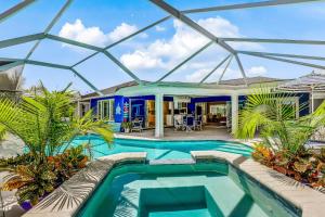 a glass house with a swimming pool and palm trees at Smiles and Sunshine in Cape Coral