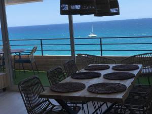een tafel met stoelen en uitzicht op de oceaan bij Panoramic sea view Lloret de Mar in Lloret de Mar