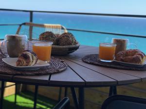 een tafel met twee borden brood en twee glazen sinaasappelsap bij Panoramic sea view Lloret de Mar in Lloret de Mar