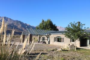 a house with a solar roof with mountains in the background at Las termas de los Molles in Los Molles