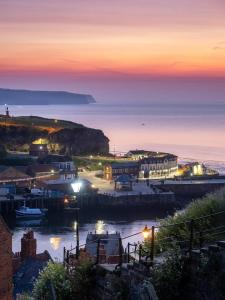 a view of a town at night with the ocean at Church Hall & Secret Garden Hideaway at Summer Hills Whitby in Whitby