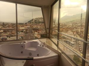 ein Badezimmer mit Badewanne und Stadtblick in der Unterkunft Vive el esplendor del Centro Histórico in Quito