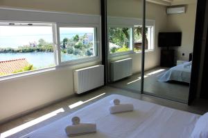 a bedroom with large windows and a bed with two meditation mats at Villa Sea View in Volos