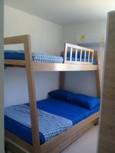 科韋尼亞斯的住宿－Coveñas campestre，配有蓝色床单的客房内的两张双层床