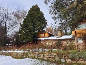 una casa en la nieve con una pared de piedra en Cabañas Las Donosas, en San Carlos de Bariloche