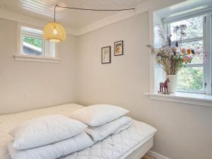 a bedroom with a bed with white sheets and a window at 6 person holiday home in Melby-By Traum in Melby