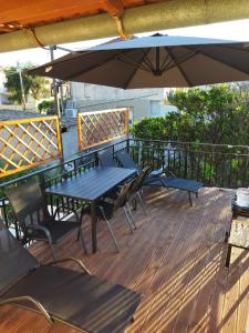 a wooden deck with a table and chairs and an umbrella at AGATHA'S HOUSE in Kouspádes