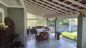 a dining room with a table and chairs on a patio at Estalagem do Rancho in Itatiaia