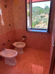 a bathroom with a toilet and a sink and a window at Agriturismo Baccanale in Prignano Cilento