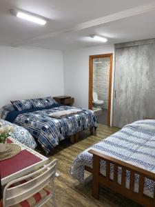 Habitación de hotel con 2 camas, mesa y sidra de mesa en Hostal Vicencio - Mini Departamentos, en Iquique