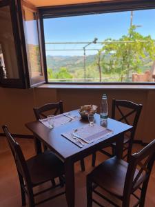 a wooden table with chairs and a bottle of water on it at Agriturismo Baccanale in Prignano Cilento