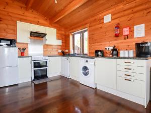 a kitchen with white appliances in a wooden cabin at Willow Lodge in Bodmin