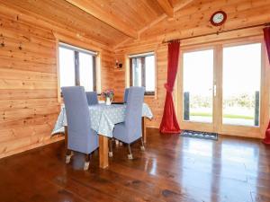 una sala da pranzo con tavolo e sedie blu di Willow Lodge a Bodmin
