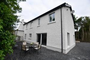 a building with a table and chairs in front of it at Kiernan's Self Catering & Accommodation in Legan