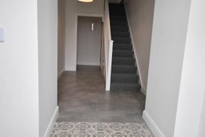 um corredor com escadas e piso em azulejo em Kiernan's Self Catering & Accommodation em Legan