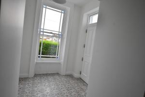 um quarto vazio com uma janela e uma porta em Kiernan's Self Catering & Accommodation em Legan