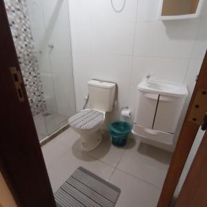 a white bathroom with a toilet and a shower at Apto Jockey 3 in Campos dos Goytacazes
