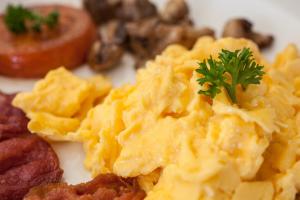 a plate of food with scrambled eggs and other foods at Palm Beach Guesthouse in Port Elizabeth