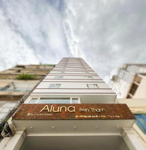 a tall white building with a sign on it at ALUNA Ben Thanh Hotel in Ho Chi Minh City