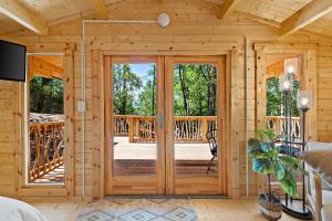uma cabina de madeira com uma grande porta de vidro em Laurel Ridge Cabin...experience nature in 90 acres! em Marion