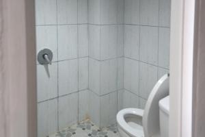 a bathroom with a tiled shower with a toilet at RedDoorz at Jalan Somba Opu Losari in Makassar
