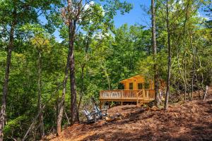 uma cabana de madeira na floresta com árvores em Laurel Ridge Cabin...experience nature in 90 acres! em Marion