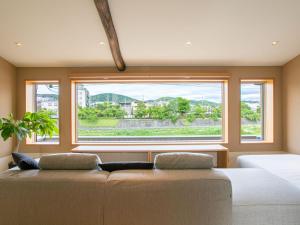 1 dormitorio con sofá y ventana grande en Shirasagi Kyoto en Kioto