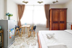 a bedroom with a bed and a table and chairs at Huyen House in Ho Chi Minh City