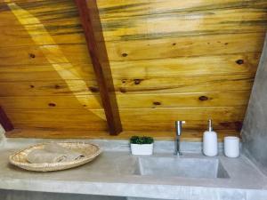 a sink in a bathroom with a wooden wall at Cabanas Bouganville in Monte das Gameleiras +8 photos