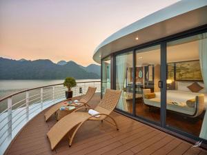 een balkon met een slaapkamer en een bed op een cruiseschip bij Halong Capella Cruise in Ha Long