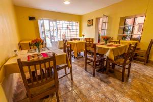 a restaurant with tables and chairs with yellow walls at Eco Inn in Cusco