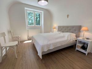 biała sypialnia z dużym łóżkiem i oknem w obiekcie Grande maison familiale à 800m de la plage de Kermor avec jardin - FR-1-481-122 w mieście Combrit