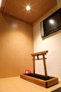 a room with a tv and a red ball on a table at 秒飛日本 頭城小京都町家溫泉之宿 in Toucheng
