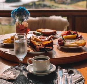 a table with plates of food and a cup of water at Tedesco Eco Park in São Francisco de Paula