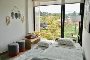 a bedroom with two beds and a large window at Cozy Stays Cayala Apartments (407) in Guatemala