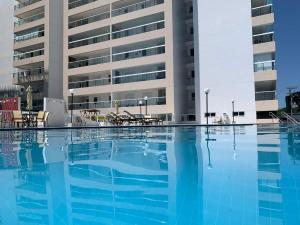 an empty swimming pool in front of a building at Apartamento em Bertioga com varanda gourmet Brisas da enseada in Bertioga
